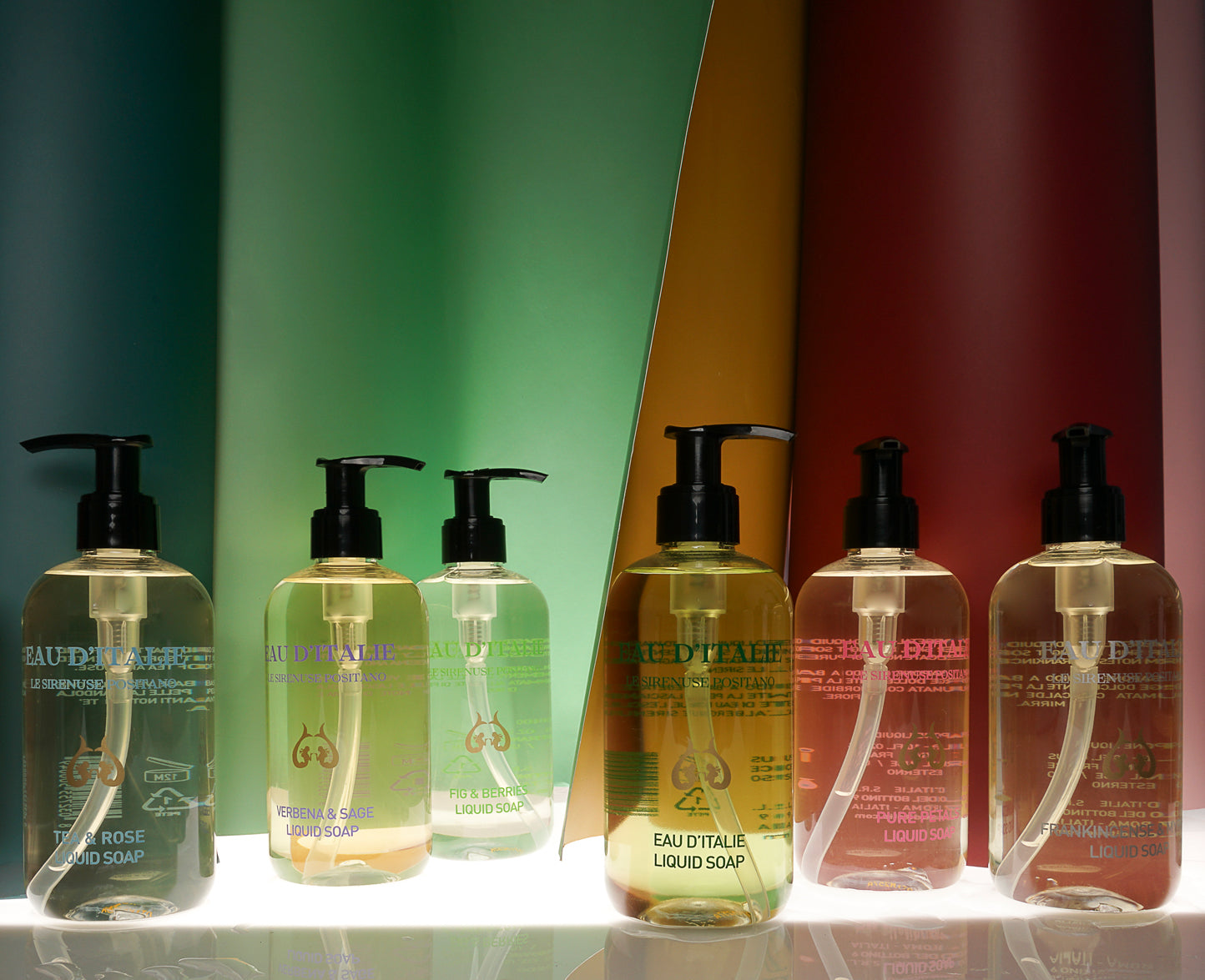 A selection of Eau d'Italie Liquid Soaps with colored drapes in the background