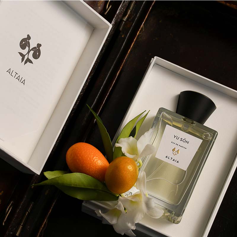 Beauty shot of ALTAIA Yu Son Eau de Parfum in box with oranges and white flowers