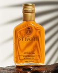 Ligne St. Barth Avocado Oil (6.8 oz) on stone with shadow of a palm leaf in the background