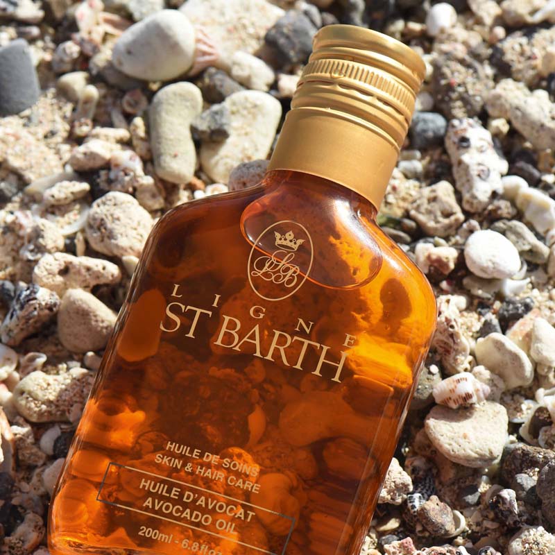 Ligne St. Barth Avocado Oil (6.8 oz) top view on top of rocky beach