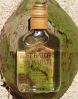 Lifestyle shot of Ligne St. Barth Coconut Dry Oil (6.8 oz) on top of a green coconut