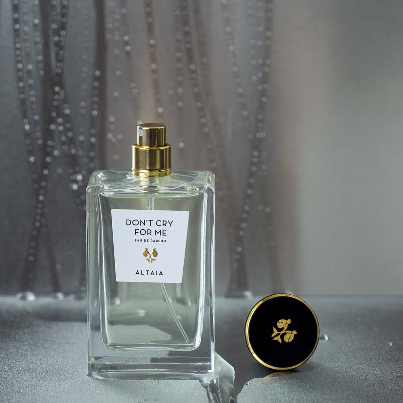 Beauty shot of ALTAIA Don&#39;t Cry For Me Eau de Parfum with cap off and water dripping down in the background