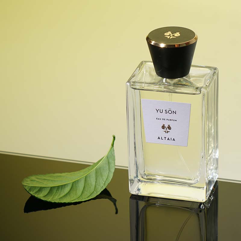 Beauty shot of ALTAIA Yu Son Eau de Parfum with single green leaf in the background