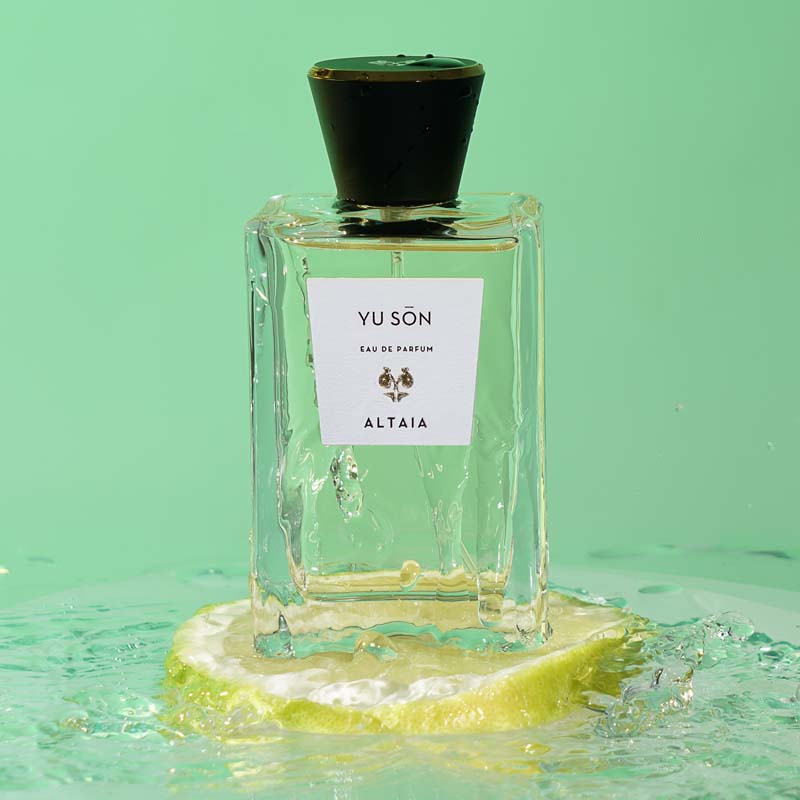 Beauty shot of ALTAIA Yu Son Eau de Parfum sitting on a slice of lemon and water in the background