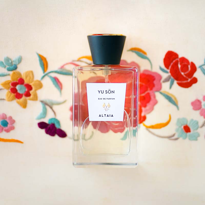 Beauty shot of ALTAIA Yu Son Eau de Parfum with embroidered flowers in the background