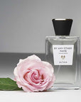 Beauty shot of ALTAIA By Any Other Name Eau de Parfum with single pink rose in the foreground