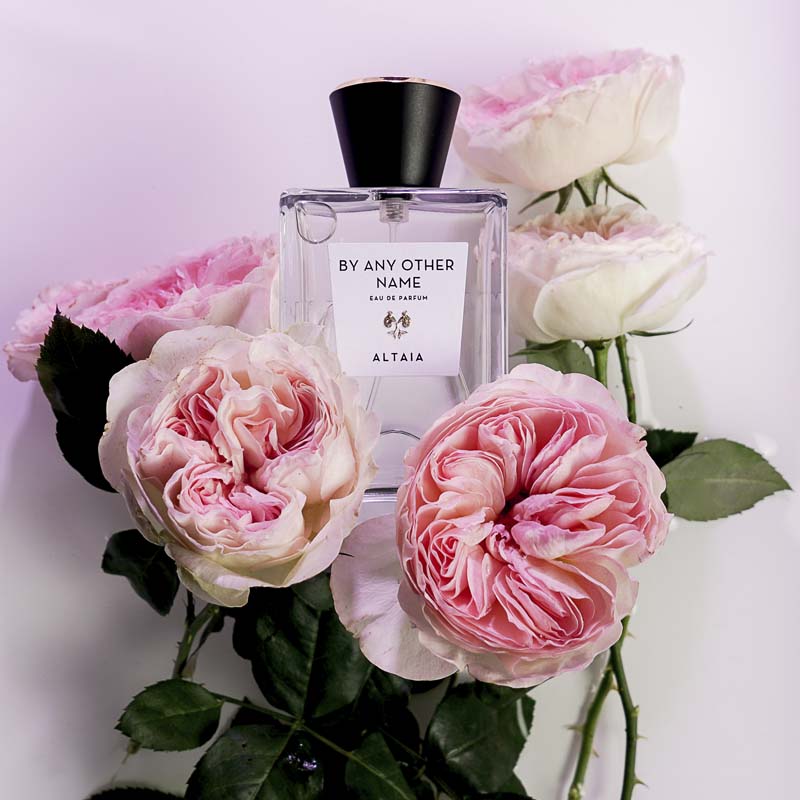 Beauty shot of ALTAIA By Any Other Name Eau de Parfum with pink roses in the background