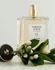 Beauty shot of ALTAIA Tuberose in Blue Eau de Parfum with top off and tuberose flowers in the foreground