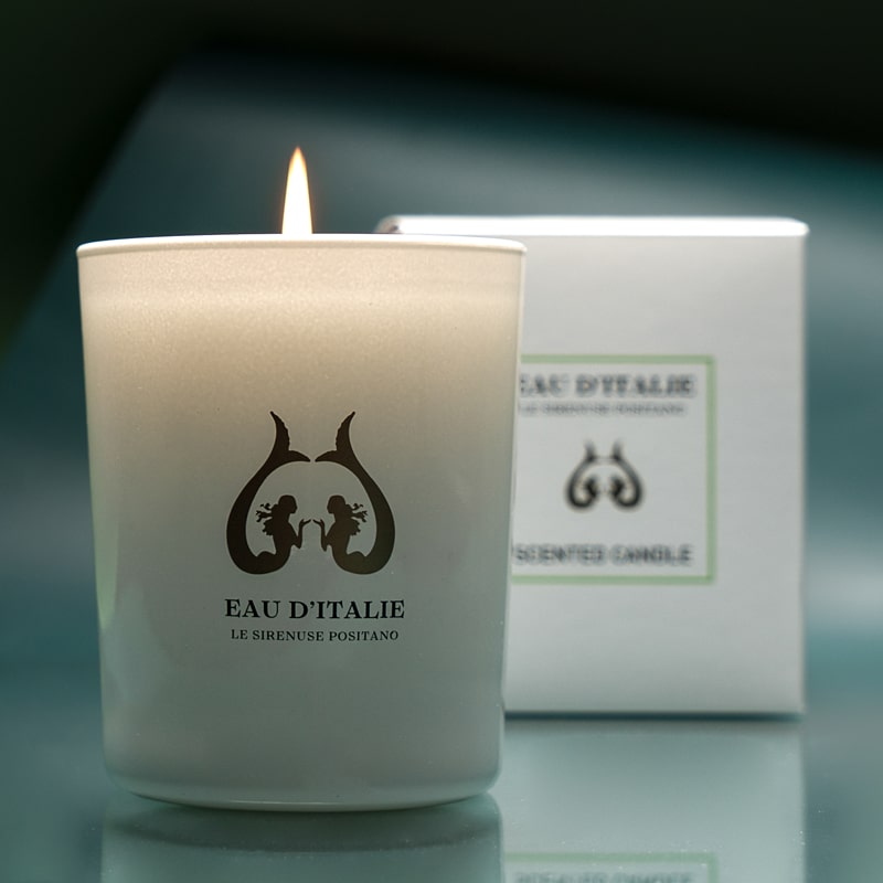 Lifestyle shot of Eau d&#39;Italie Scented Candle (190 g) shown burning with box in the background