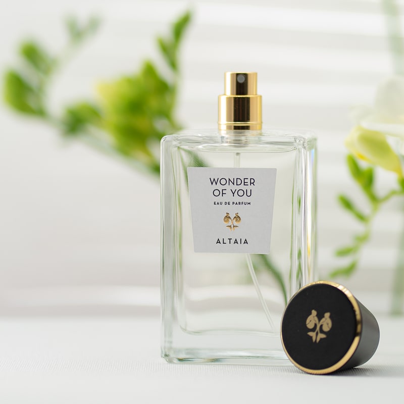 Lifestyle shot of ALTAIA Wonder of You Eau de Parfum (100 ml) with top of bottle off and posed facing front