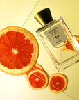 Lifestyle shot of ALTAIA Wonder of You Eau de Parfum (100 ml) with citrus slices in the background