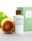 Lifestyle shot of Eau d'Italie Jardin du Poete Eau de Parfum Spray (100 ml) with box and citrus in the background