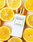 Lifestyle shot top view of Eau d'Italie Acqua Decima Eau de Parfum Spray (100 ml) with lemon slices around the bottle