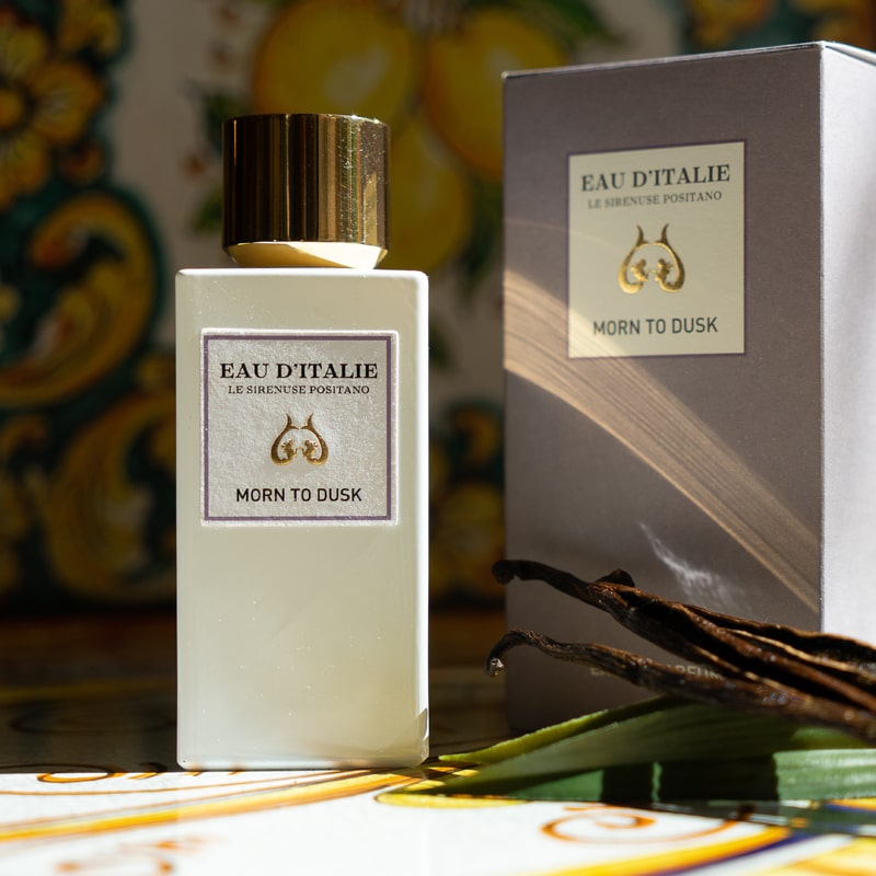 Lifestyle shot of Morn to Dusk Eau de Parfum Spray (100 ml) with box and vanilla pods in the foreground