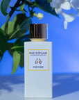 Lifestyle shot of Eau d'Italie Fior Fiore Eau de Parfum Spray (100 ml) with white flowers in the background