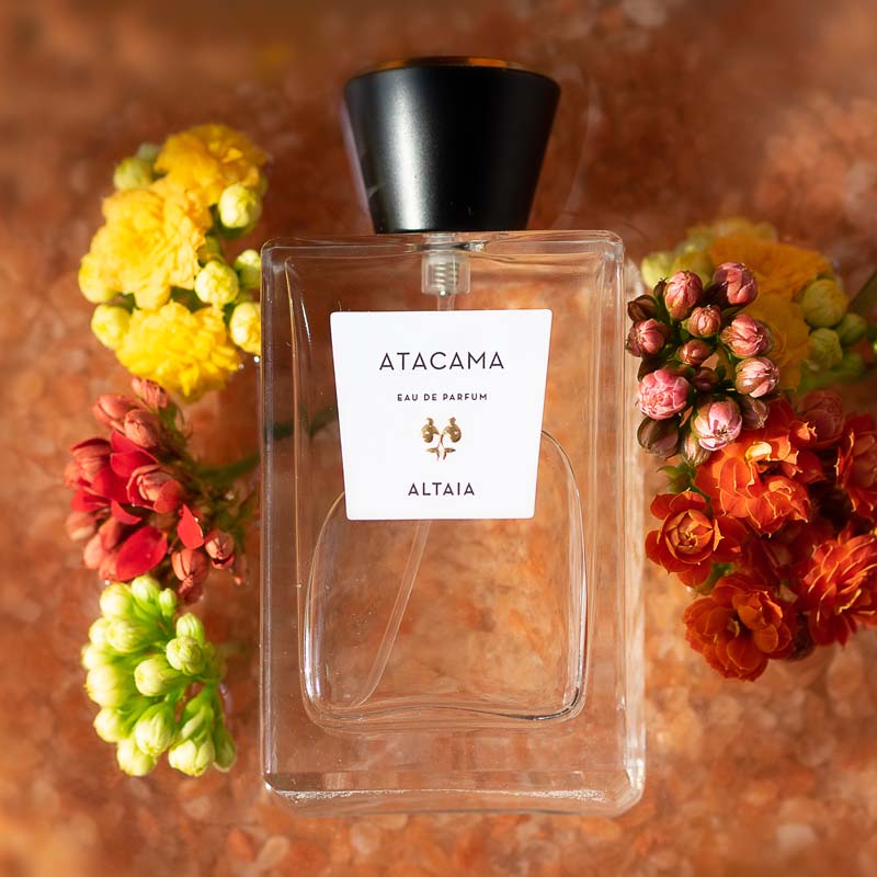 ALTAIA Atacama Eau de Parfum beauty shot on pile of Himalayan Pink Salt and yellow, red and green flowers in the background