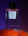 ALTAIA Atacama Eau de Parfum beauty shot with dark purple background and bottle on orange surface