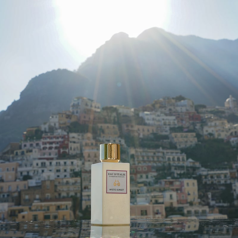 Eau d&#39;Italie Mystic Sunset Eau de Parfum Spray (100 ml) with the Positano cliffside in the background