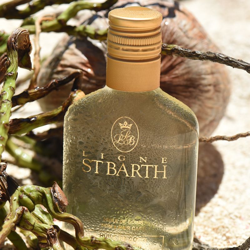 Beauty shot of Ligne St. Barth Coconut Oil bottle with coconut in the background