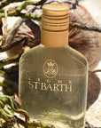 Beauty shot of Ligne St. Barth Coconut Oil bottle with coconut in the background