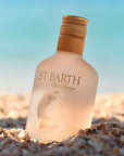 Beauty shot of Ligne St. Barth Sea Breeze Sunsplash Face & Body Splash 200 ml on the beach with ocean in the background